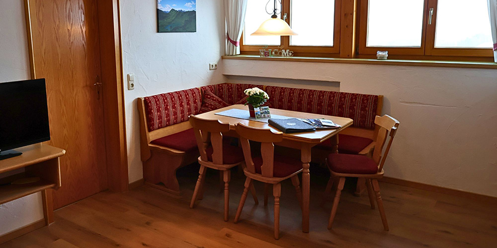 Gemütlicher Essbereich mit Kinderhochstuhl – perfekt für gemeinsame Familienzeit in der Ferienwohnung Grüntenblick