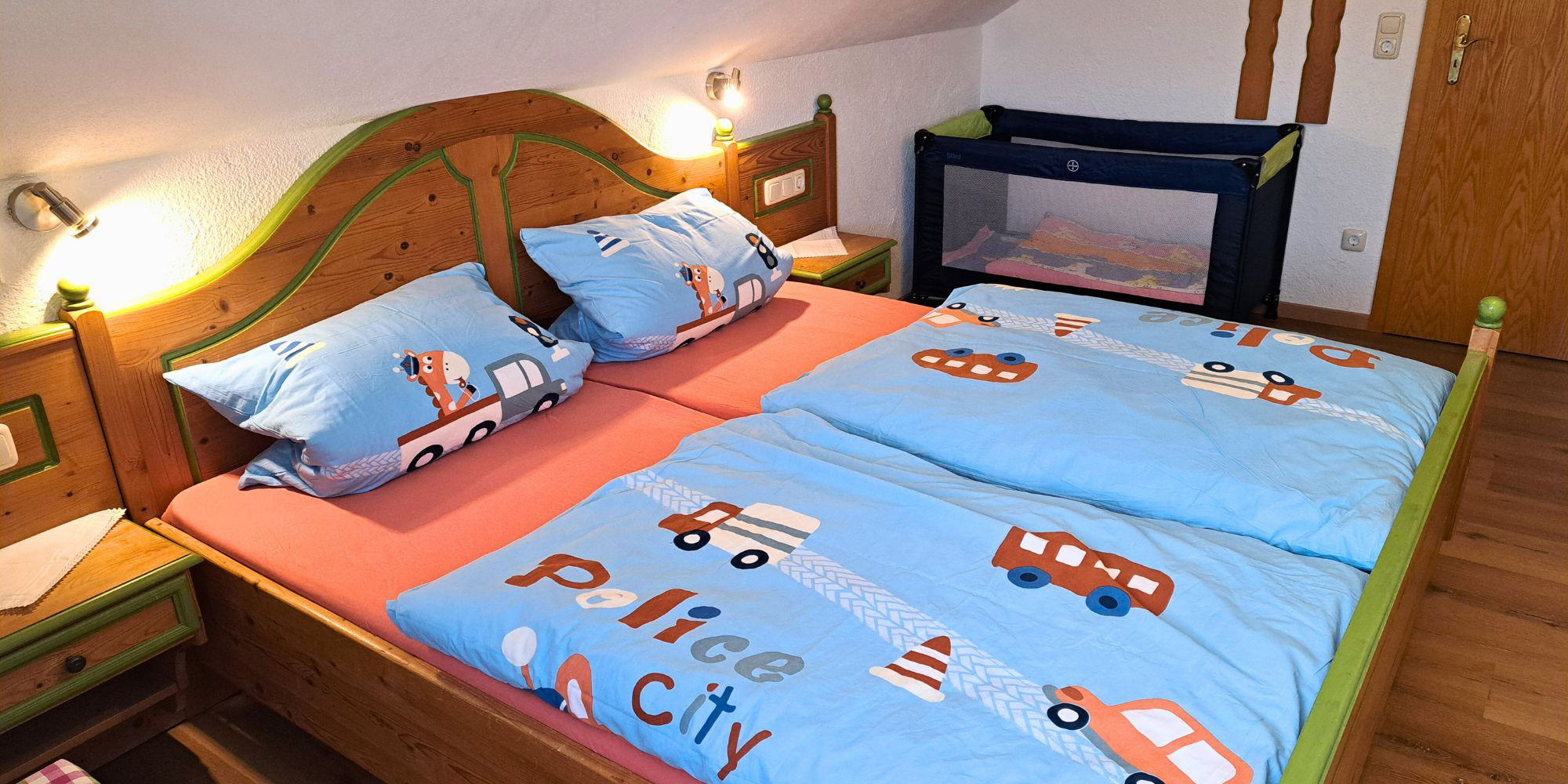 Zweites Schlafzimmer der Ferienwohnung Grüntenblick mit Kinderbett, Gitterbett und kindgerechter Ausstattung – ideal für Familienurlaub im Allgäu