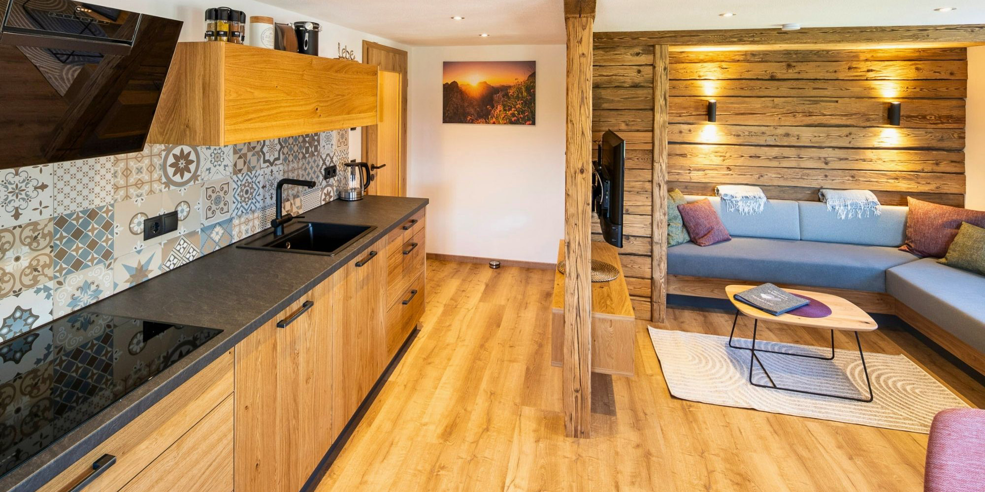 Stilvolle Wohnküche der Ferienwohnung Morgensonne mit Holzfronten, Sofa-Ecke und moderner Ausstattung auf dem Ferienhof Eger im Allgäu